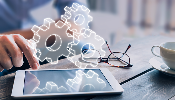 Über einem Tablet greifen virtuelle Zahnräder ineinander. Das verdeutlicht wie Synergien entstehen - zwischen Lerncontent und Content für Online-Marketing